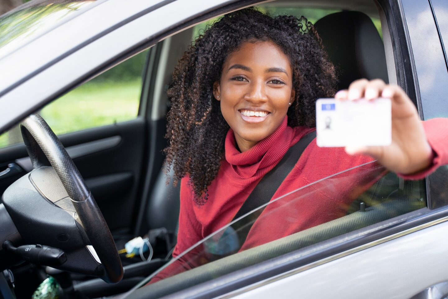 Illinois driver license reinstatement FAQ - woman holding renewed drivers license